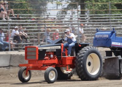 A man riding on the back of an orange tractor.